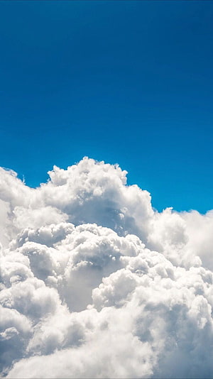 Majestic Fluffy White Cumulus Clouds Against a Deep Blue Sky HD phone wallpaper