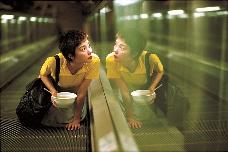 Chungking Express still of a woman in a yellow shirt eating noodles on a moving walkway with a glass reflection, Wong Kar Wai Has Written A Chungking Express Sequel HD wallpaper