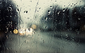 Macro Raindrops on Glass with Blurred City Lights and Water Streaks HD wallpaper