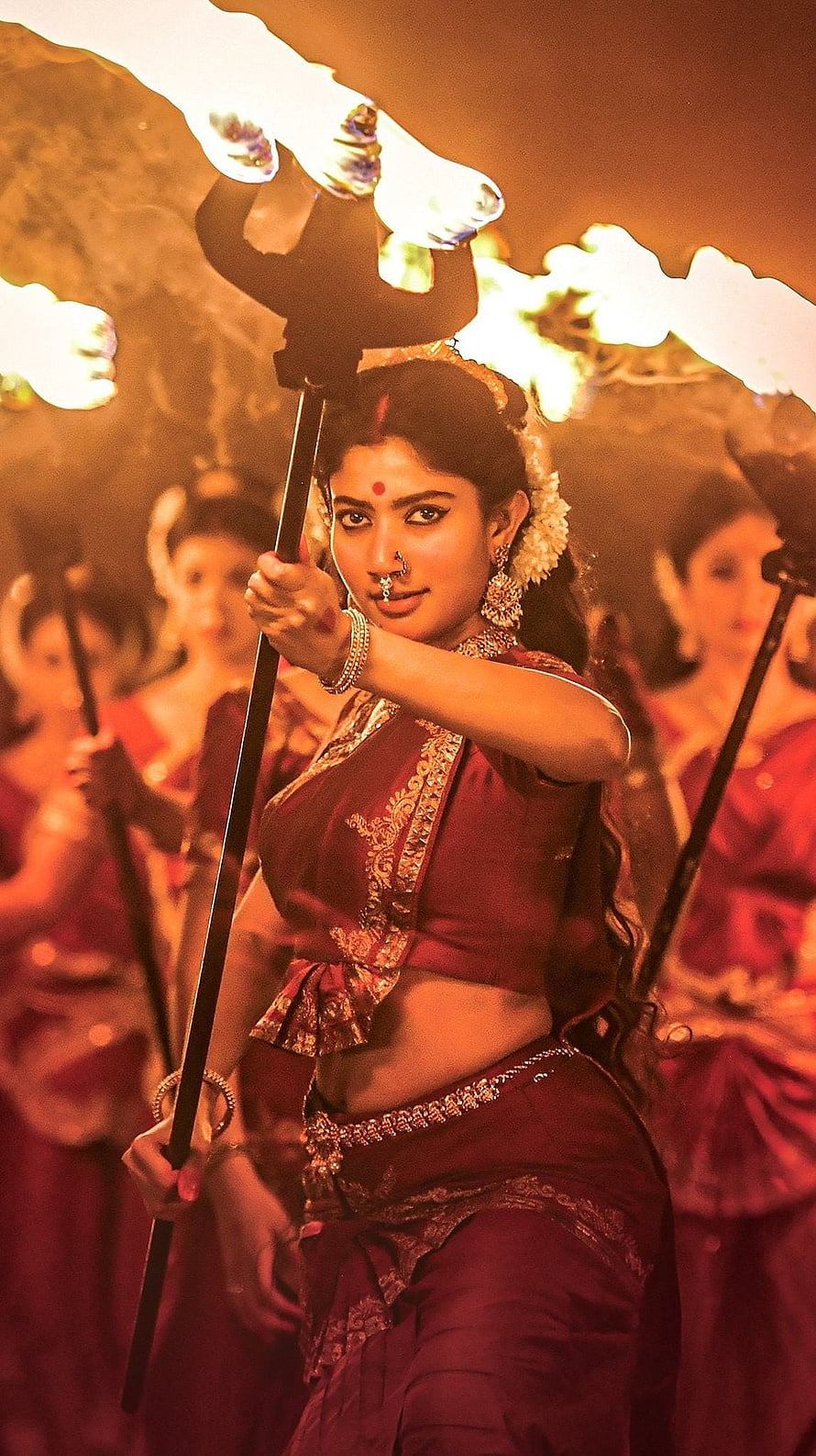 Sai Pallavi in Traditional Maroon Attire Holding a Torch During a Dramatic Performance HD phone wallpaper