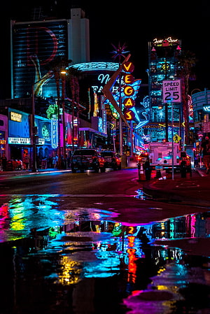 Vibrant Las Vegas Strip at Night with Neon Sign Reflections in Street Puddles HD phone wallpaper