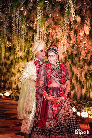 Traditional Indian Wedding Couple in Ornate Attire with Floral Garland HD phone wallpaper