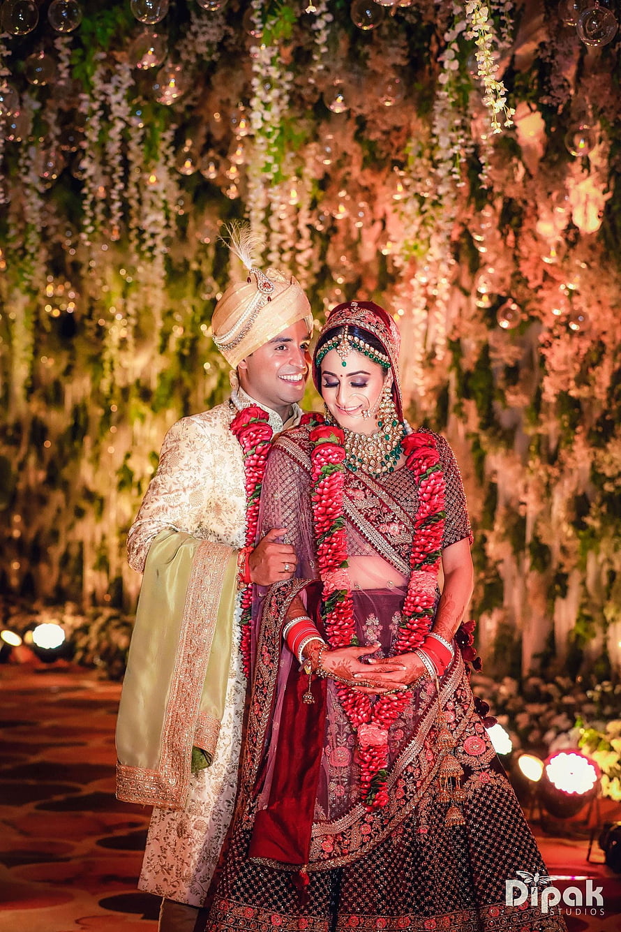 Traditional Indian Wedding Couple in Ornate Attire with Floral Garland HD phone wallpaper