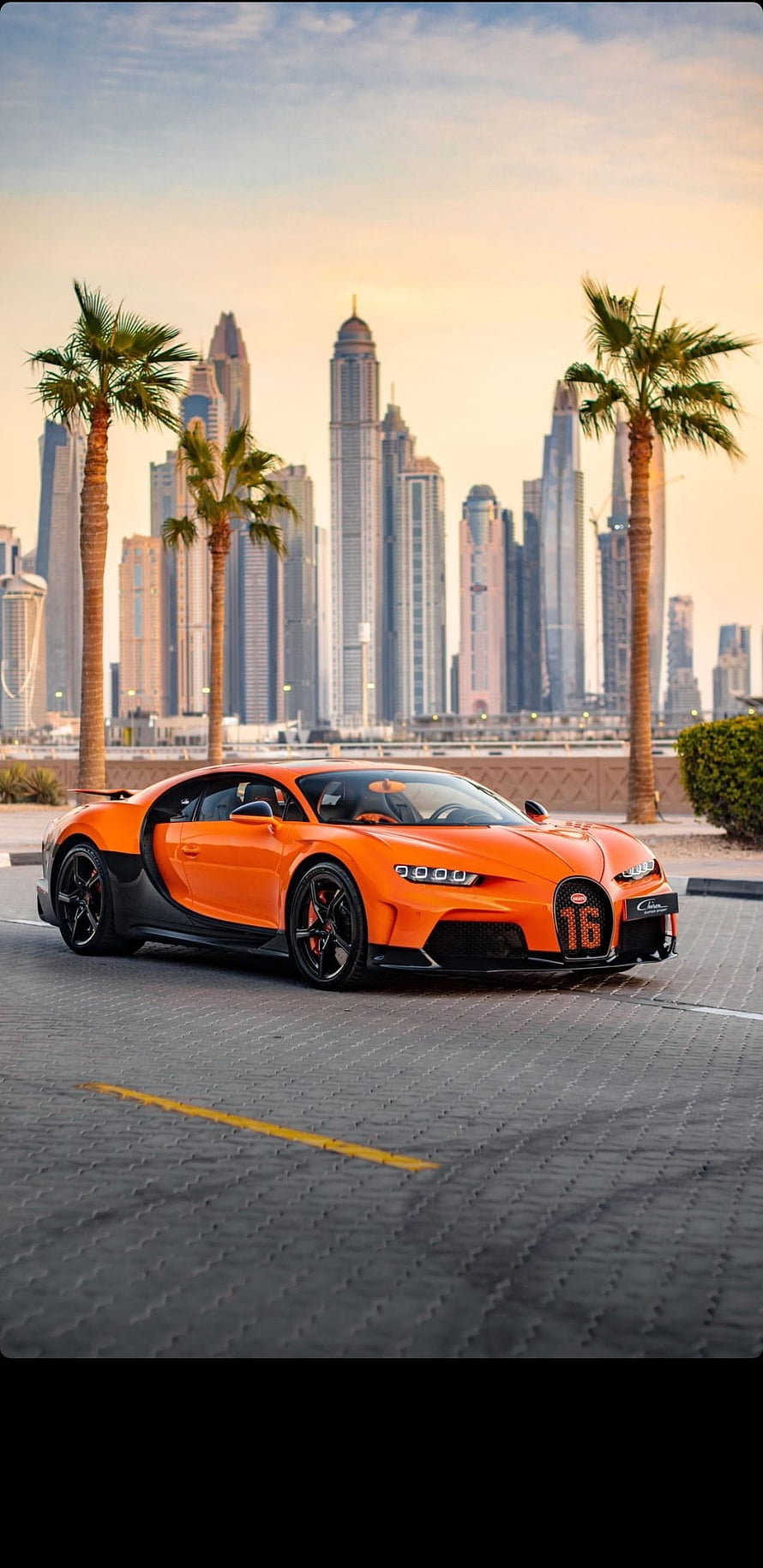Orange Bugatti Chiron Super Sport 300+ parked in Dubai Marina with skyline HD phone wallpaper