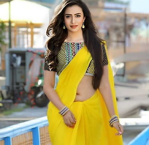 Sana Javed in a vibrant yellow sari with a patterned blouse and traditional jewelry HD wallpaper