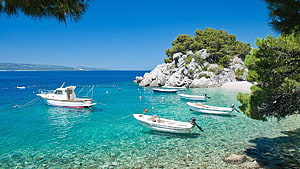 Turquoise Waters and Moored Boats in a Secluded Greek Island Cove HD wallpaper