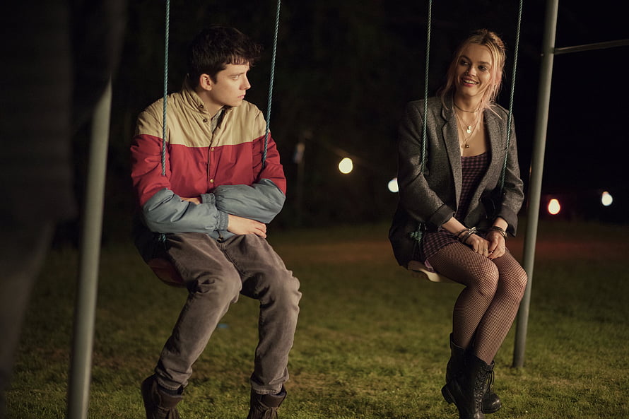 Asa Butterfield as Otis and Maeve on a Nighttime Playground Swing HD wallpaper