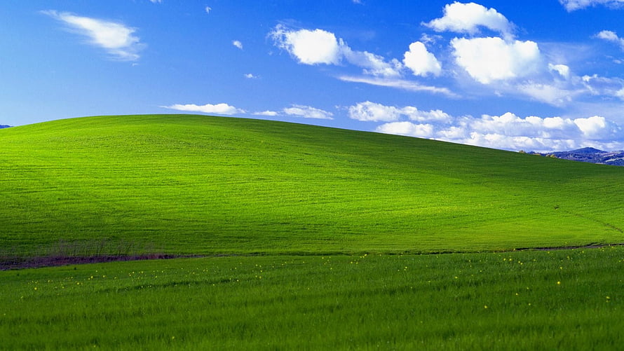 Vibrant Green Rolling Hills Under a Bright Blue Sky with Fluffy White Clouds HD wallpaper