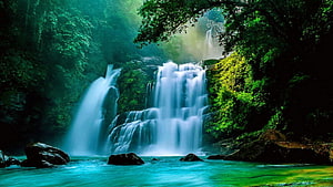 Serene Multi-Tiered Waterfall Cascading Through Lush Green Forest HD wallpaper
