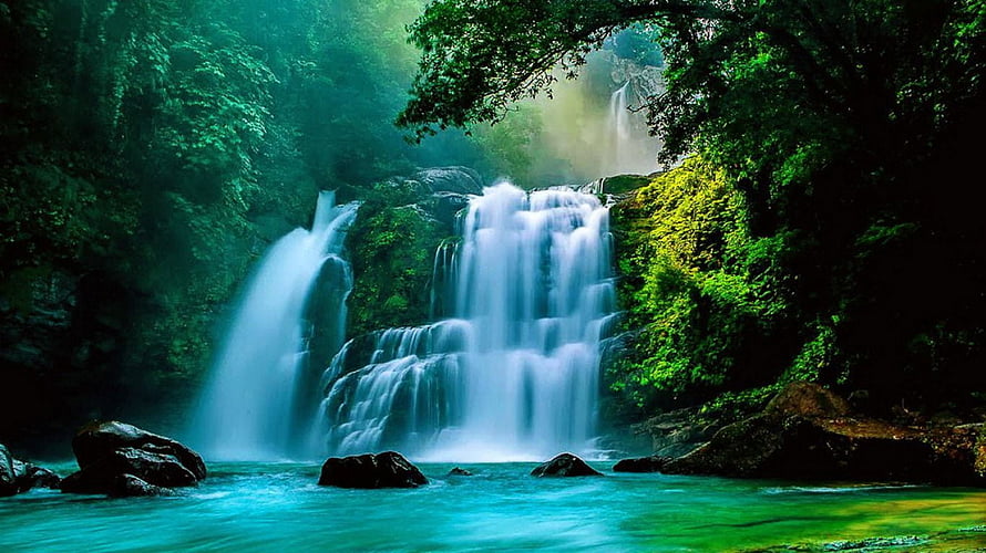 Serene Multi-Tiered Waterfall Cascading Through Lush Green Forest HD wallpaper