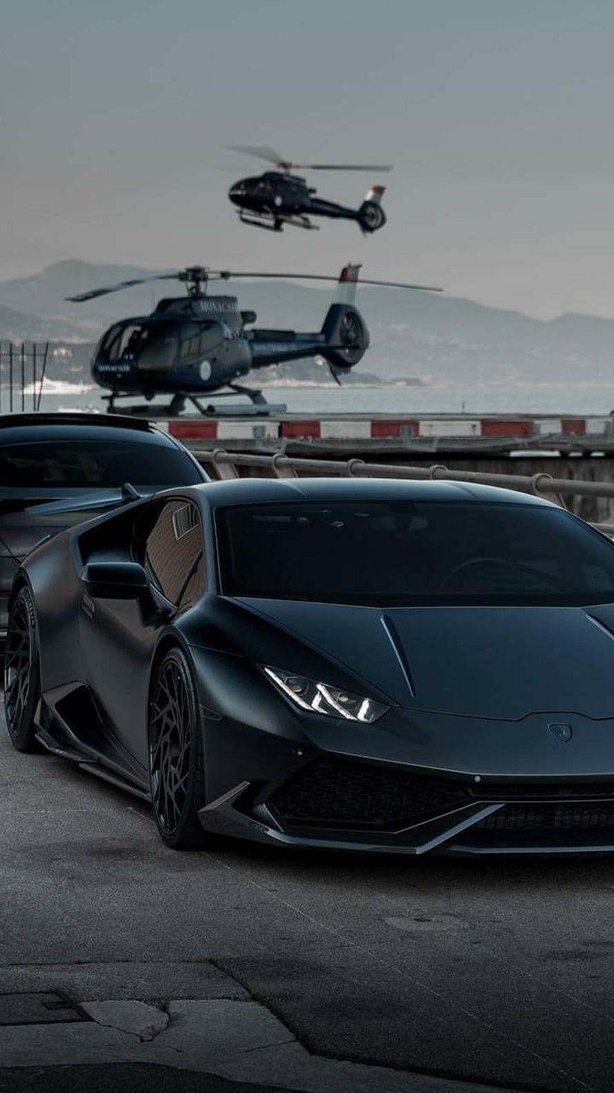 Matte Black Lamborghini Huracan Parked Near Helicopters at Coastal Heliport HD phone wallpaper
