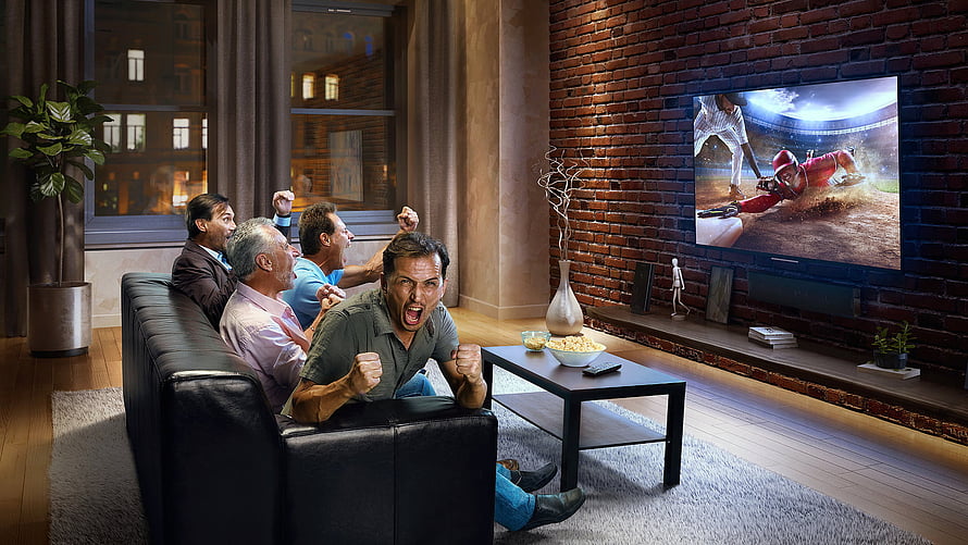Group of friends cheering while watching a cricket match on a large flat screen TV in a modern living room HD wallpaper