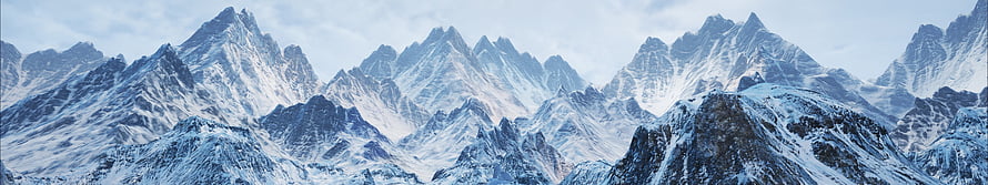 Majestic Snow-Covered Mountain Range Panorama with Jagged Peaks and Icy Valleys HD wallpaper