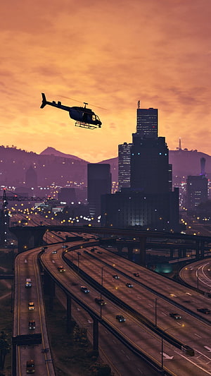 Grand Theft Auto V Cityscape at Sunset with Helicopter Over Highway Interchange HD phone wallpaper