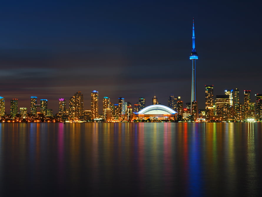 Toronto skyline at night with CN Tower and waterfront reflections on Lake Ontario HD wallpaper