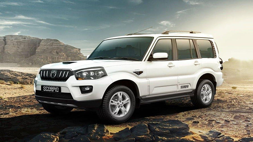 White Mahindra Scorpio SUV parked on rocky desert terrain with dramatic sky backdrop HD wallpaper