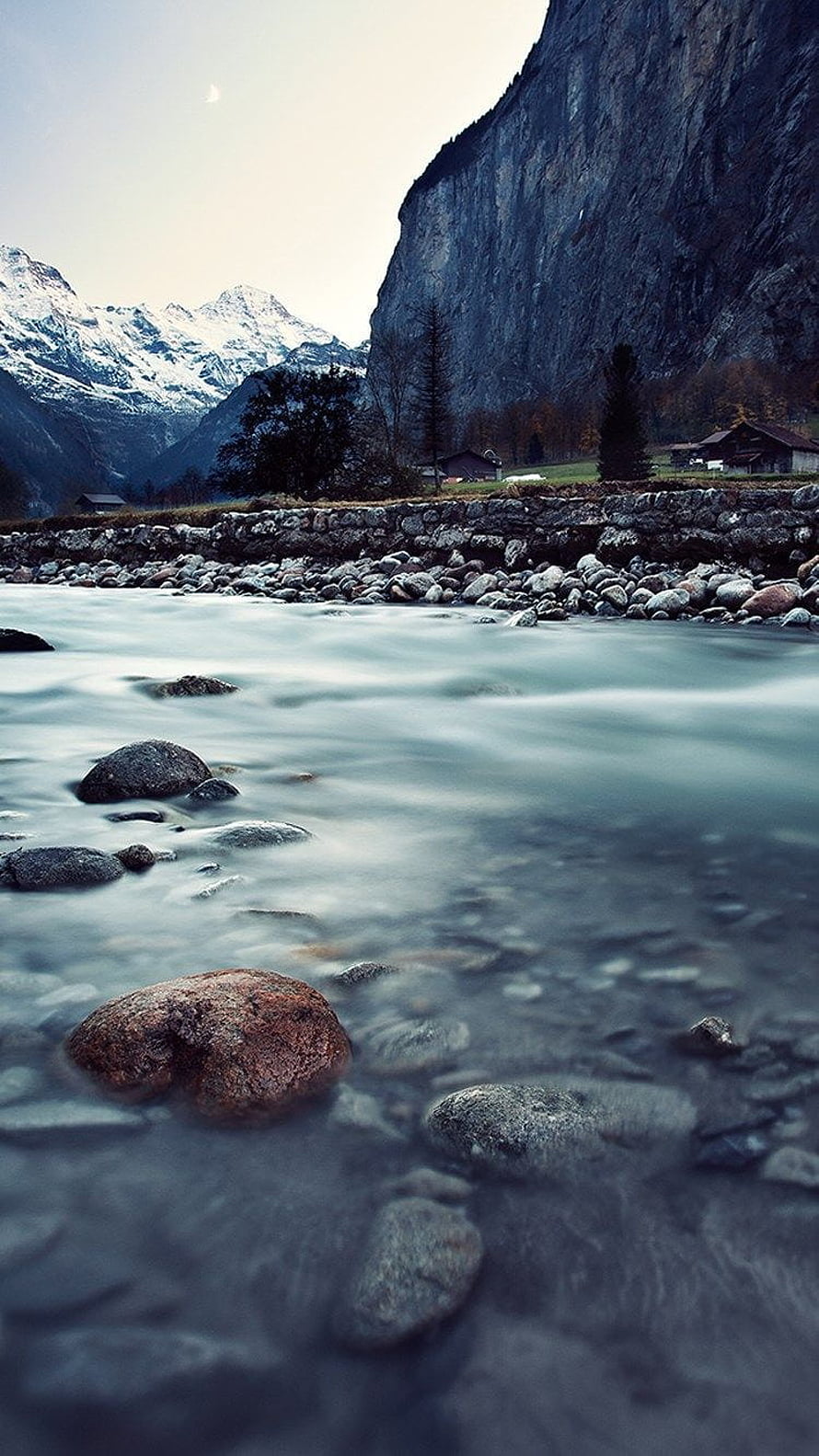 Alpine River Valley with Snow-Capped Peaks and Rustic Cottages HD phone wallpaper