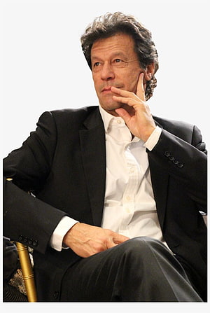 Imran Khan in a black suit and white shirt seated in a thoughtful pose HD phone wallpaper