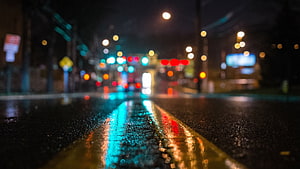 Rainy City Street at Night with Blurred Bokeh Lights and Wet Asphalt Reflections HD wallpaper