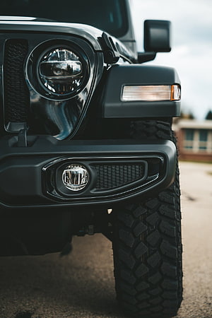 Close-Up of Black Jeep Wrangler Front Headlight and Off-Road Tire Detail HD phone wallpaper