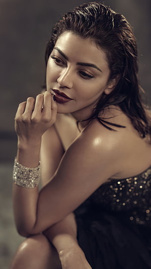 Kajal Agarwal in a moody studio portrait wearing a sequined gown and sparkling cuff bracelet HD phone wallpaper