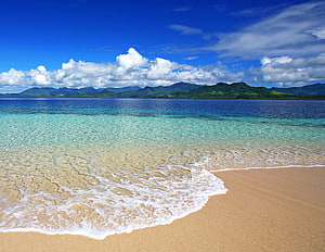 Tropical Beach With Turquoise Water And Distant Mountains HD wallpaper