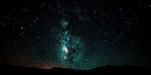 Milky Way Galaxy Arching Over a Dark Mountain Silhouette in a Star-Filled Night Sky HD wallpaper