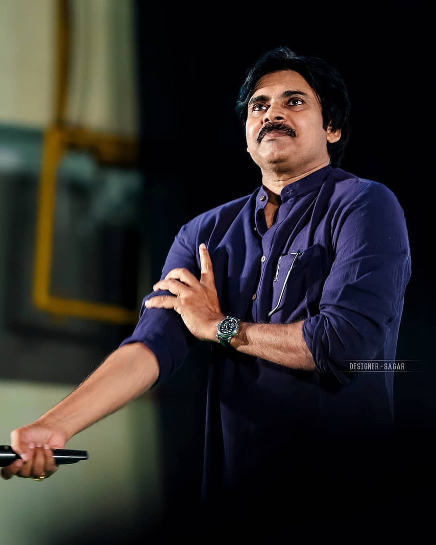 Pawan Kalyan in a navy blue shirt gesturing on stage with a microphone HD phone wallpaper