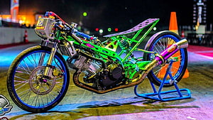 Vibrant Green Custom Drag Bike with Neon Exhaust and Blue Rims at Night HD wallpaper