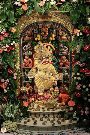 Vibrant Jagannath Temple Deity Statue Surrounded by Lush Floral Decorations and Monkeys HD phone wallpaper