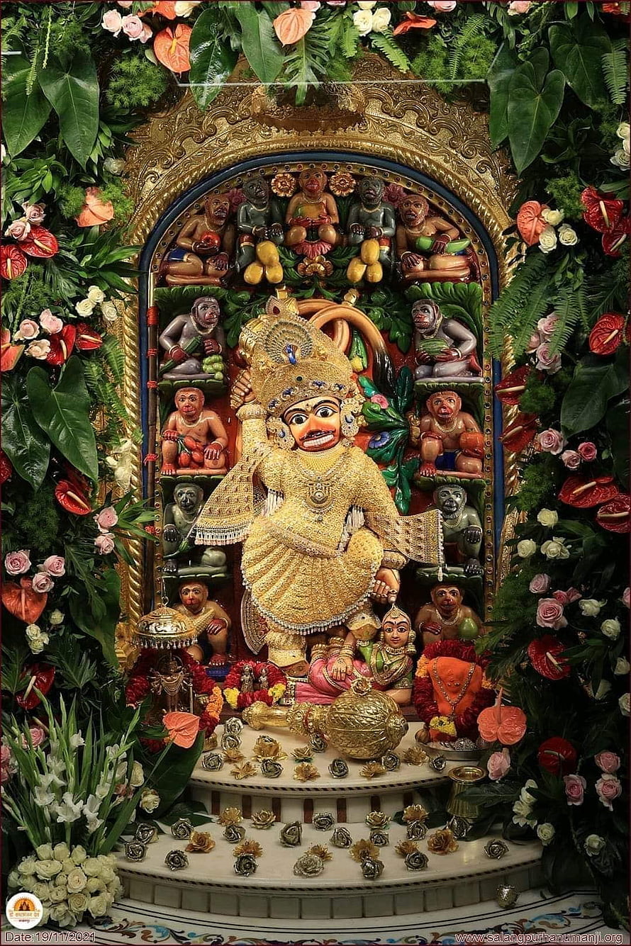 Vibrant Jagannath Temple Deity Statue Surrounded by Lush Floral Decorations and Monkeys HD phone wallpaper