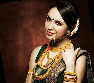 Elegant Indian Woman in Traditional Green Saree with Gold Jewelry and Floral Hairpiece, Mood , Jewellery Model HD wallpaper
