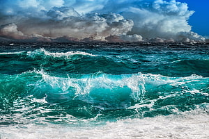 Dramatic Turquoise Ocean Waves Crashing Under Stormy Clouds HD wallpaper