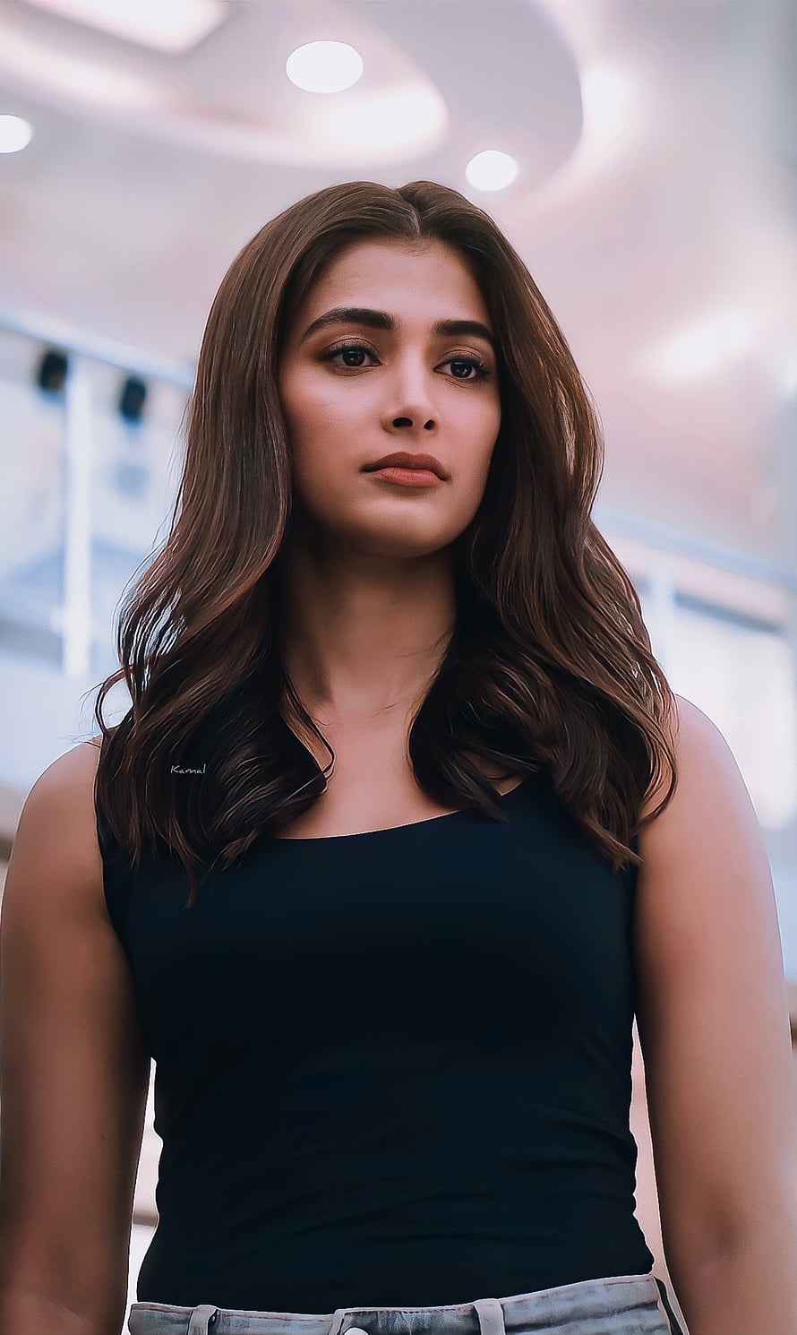 Pooja Hegde in a black tank top with wavy brown hair looking at the camera HD phone wallpaper