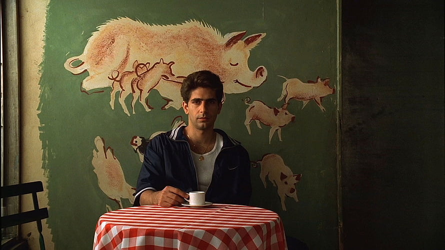 The Sopranos Character Seated at Table with Red Checkered Cloth Against Green Pig Mural HD wallpaper