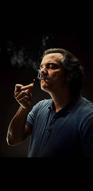 Pablo Escobar Smoking Cigar in Dramatic Low-Key Portrait HD phone wallpaper