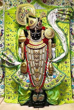 Ornate Black Idol of Lord Jagannath Adorned in Green Silk and Gold Jewelry HD phone wallpaper