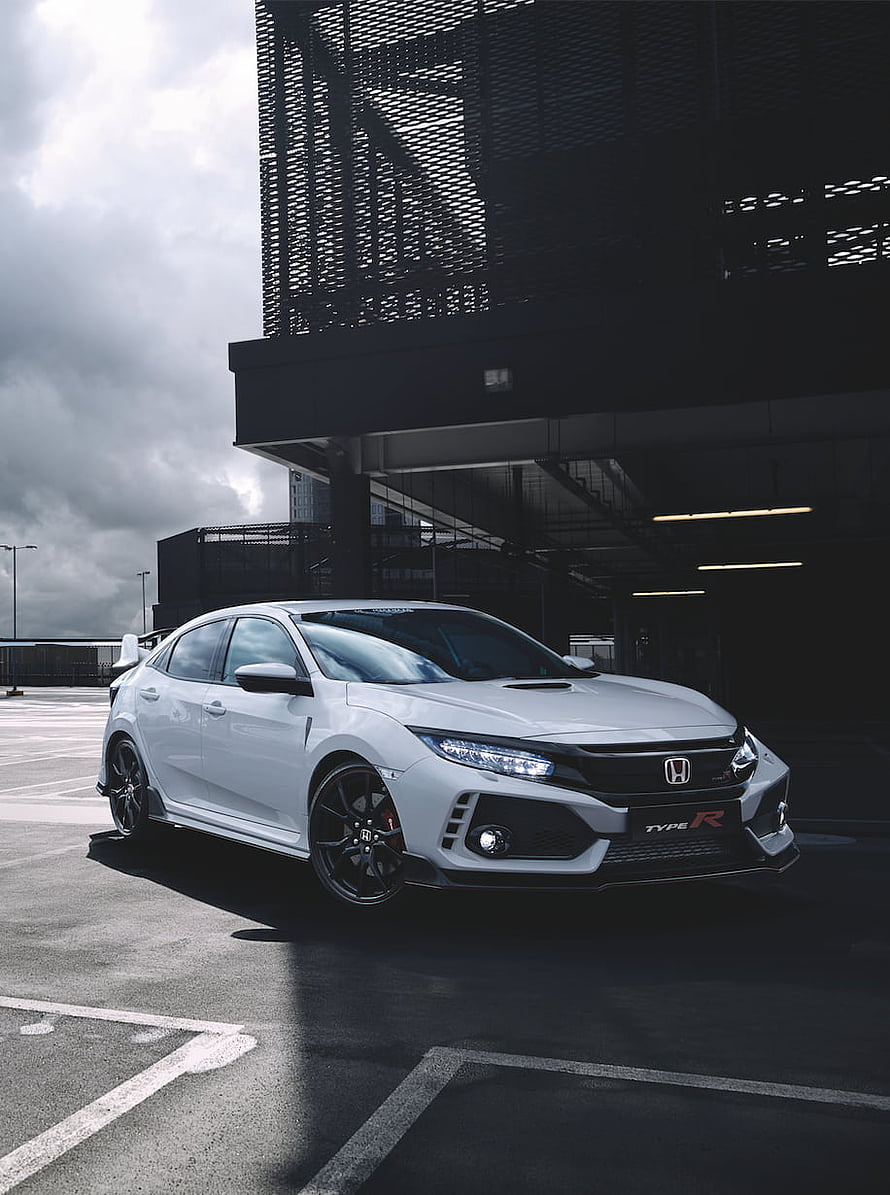 White Honda Civic Type R parked in a modern parking structure under a dramatic cloudy sky HD phone wallpaper