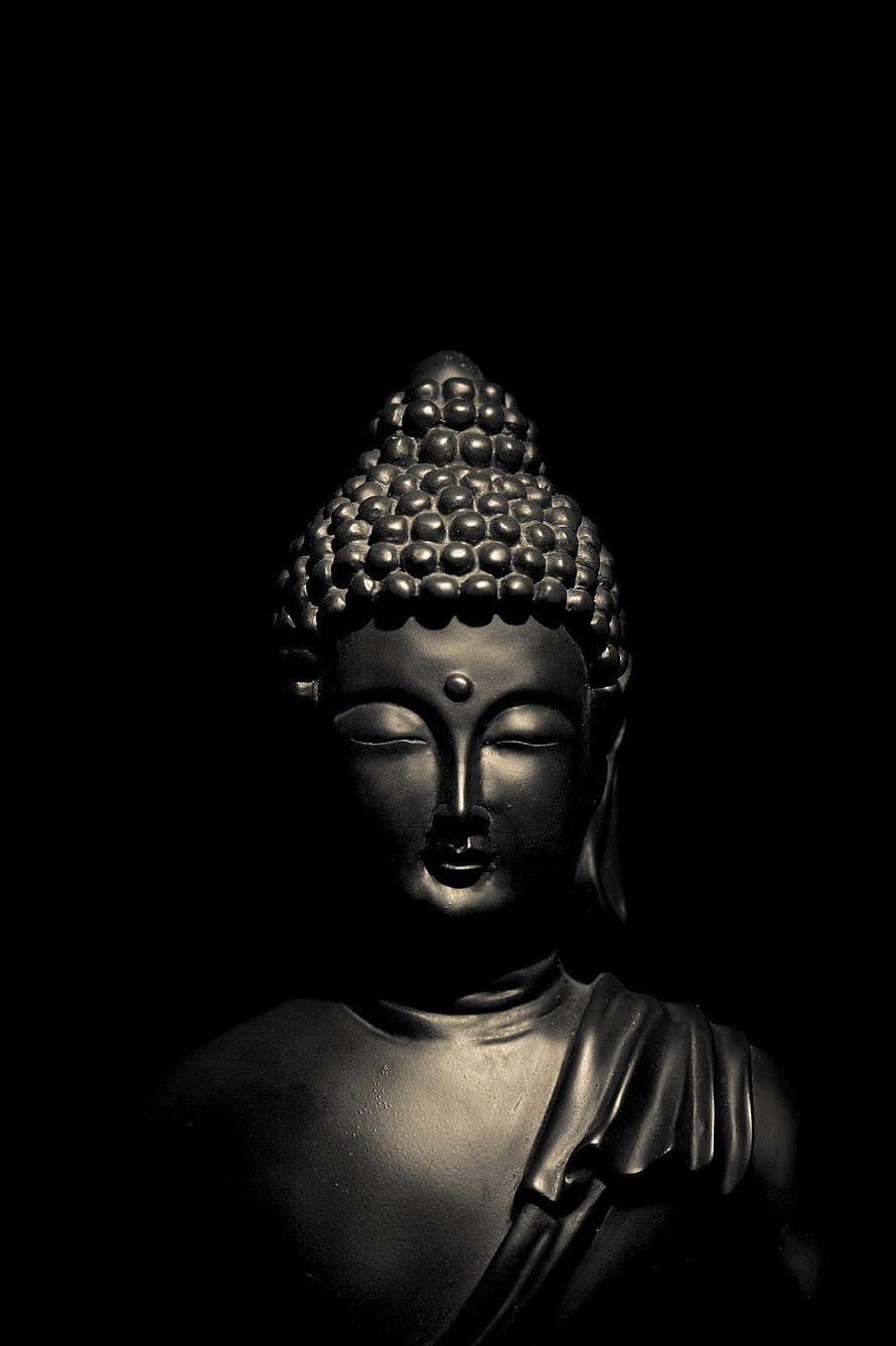 Dark moody black Buddha statue head close-up with dramatic lighting and shadows HD phone wallpaper