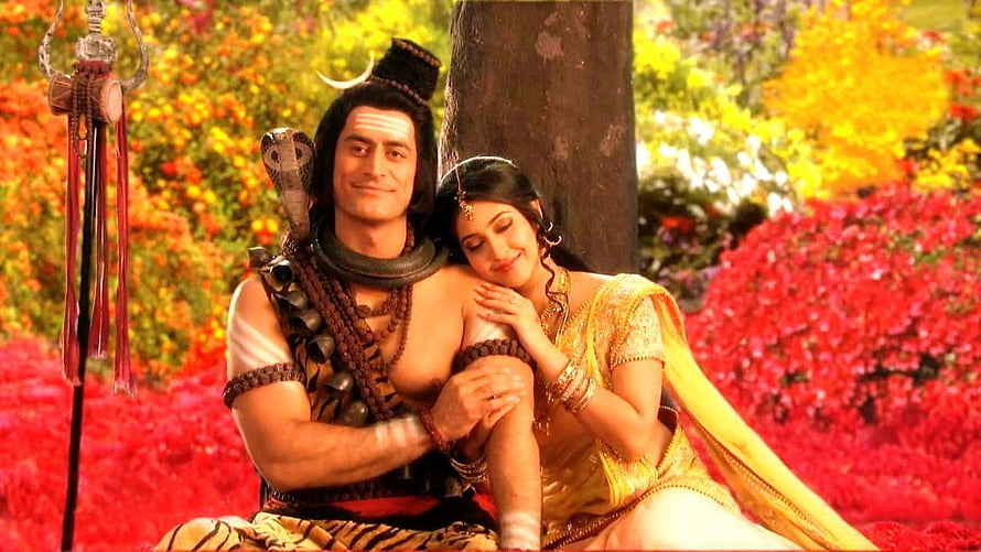 Shiva and Parvati sitting together in a vibrant garden with flowers HD wallpaper