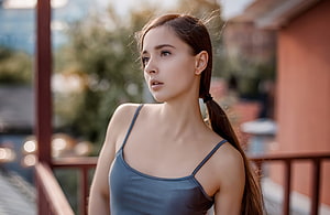 Portrait of a young woman with long brown hair in a ponytail wearing a blue tank top standing on a balcony, Gorgeous, brunette, teen model HD wallpaper