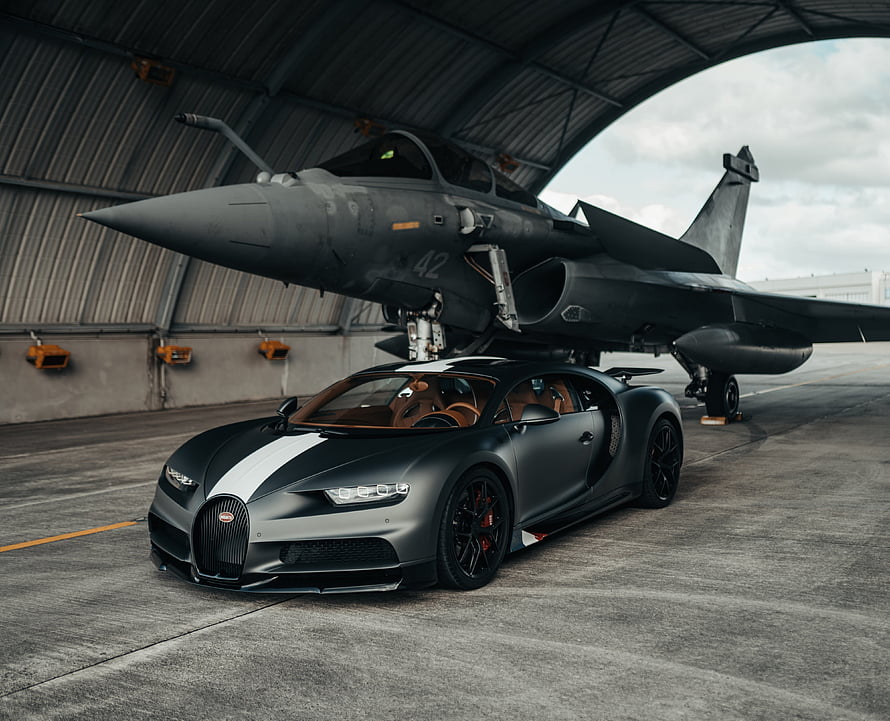Matte Black Bugatti Chiron Super Sport 300+ Parked Under Military Jet in Hangar HD wallpaper