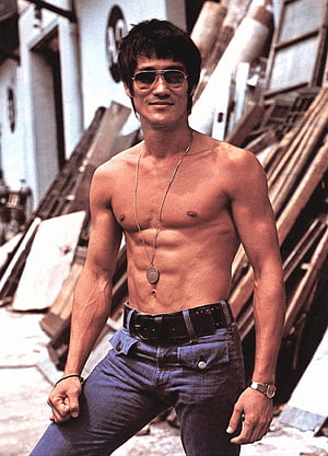 Bruce Lee shirtless portrait wearing aviator sunglasses and dog tags in an urban alleyway HD phone wallpaper