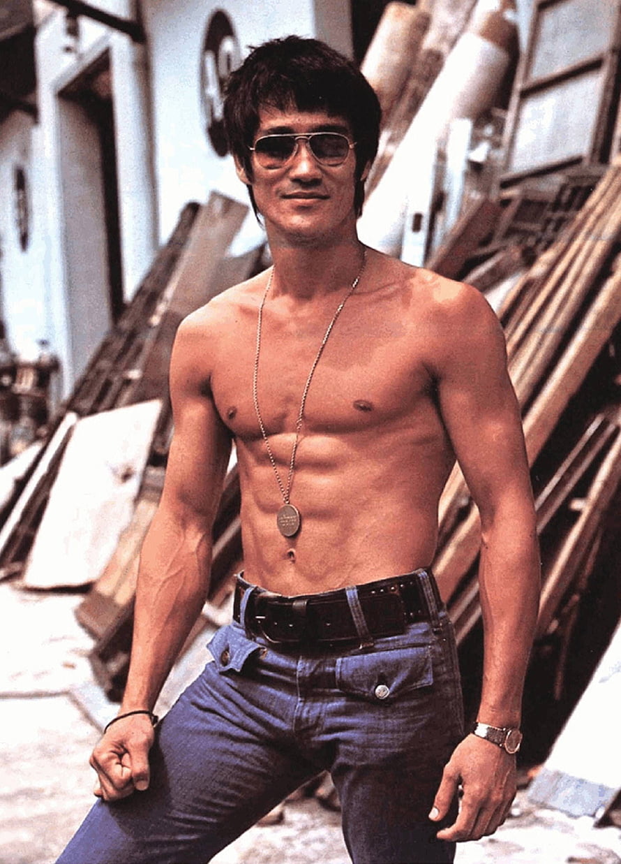 Bruce Lee shirtless portrait wearing aviator sunglasses and dog tags in an urban alleyway HD phone wallpaper