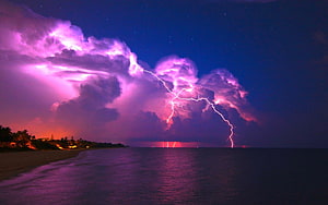 Dramatic Purple Lightning Storm Over Ocean Beach at Night HD wallpaper