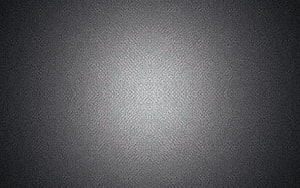Minimalist Gray Paper Texture with Soft Central Light Gradient and Subtle Vignette HD wallpaper