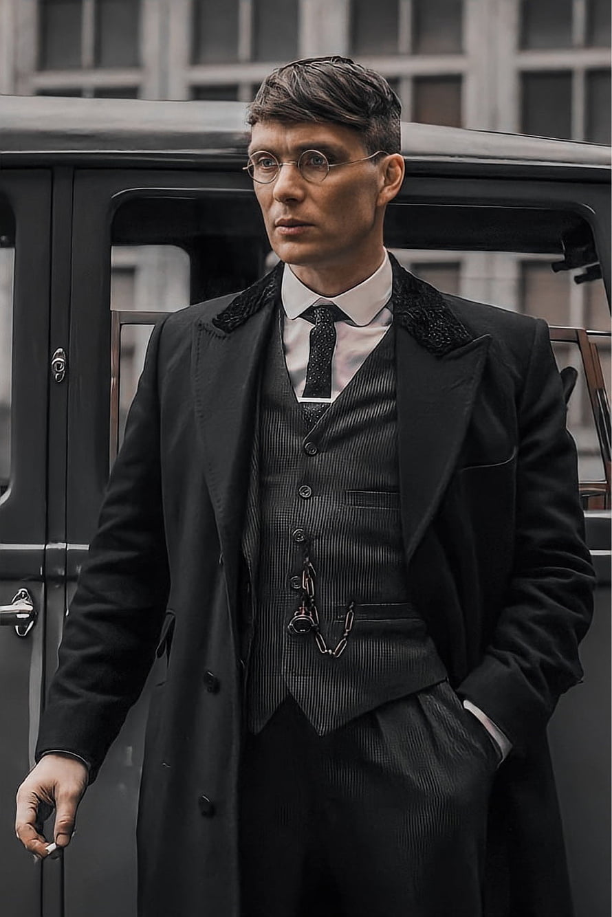 Thomas Shelby in a dark three-piece suit and round glasses standing beside a vintage car HD phone wallpaper