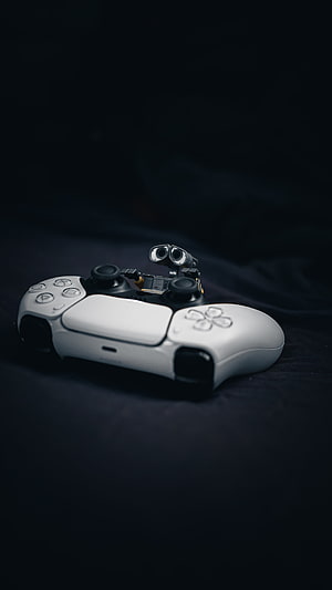 PlayStation 5 DualSense Controller with Wall-E Robot Figure on Dark Background HD phone wallpaper