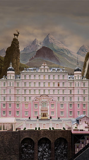 Grand Budapest Hotel Pink Facade Set Piece with Alpine Mountain Backdrop and Deer Statue HD phone wallpaper