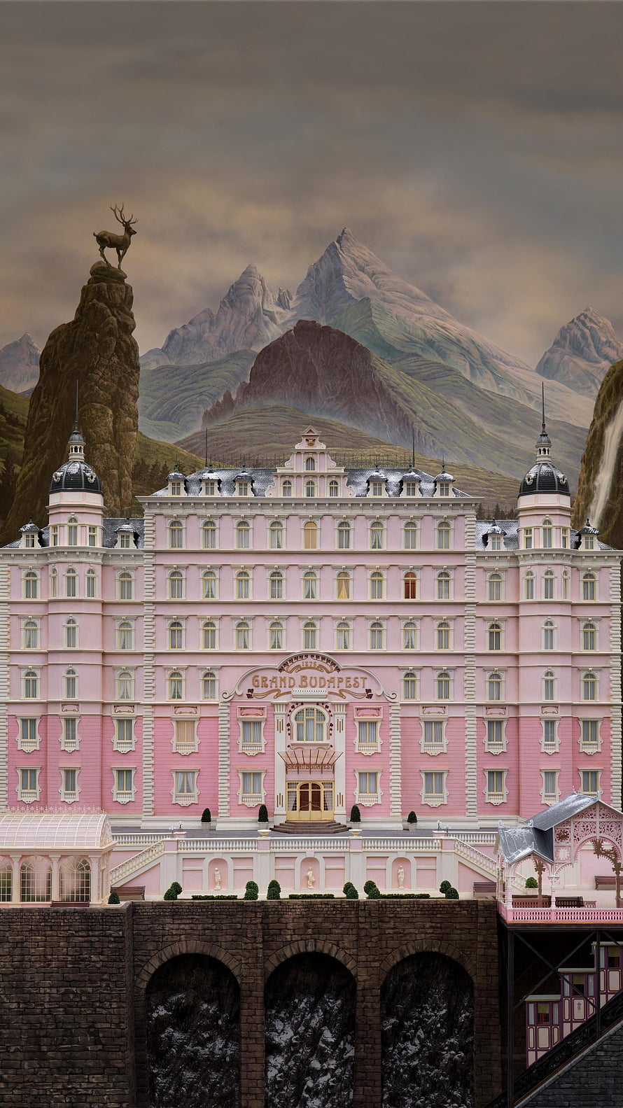 Grand Budapest Hotel Pink Facade Set Piece with Alpine Mountain Backdrop and Deer Statue HD phone wallpaper